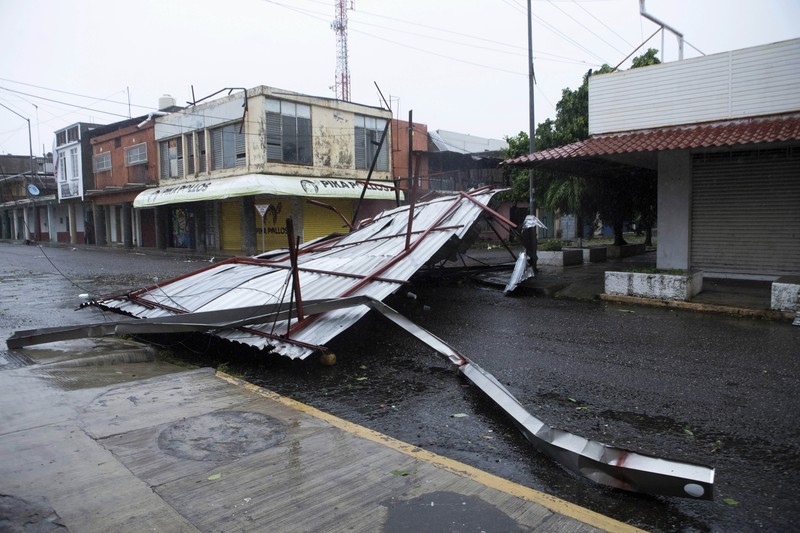 A car is stuck in a flooded street due to Hurricane Rick in Lazaro Cardenas, Mexico, Monday, Oct. 25, 2021. Hurricane Rick roared ashore along Mexico's southern Pacific coast early Monday with winds and heavy rain amid warnings of potential flash floods in the coastal mountains. (AP Photo/Armando Solis)