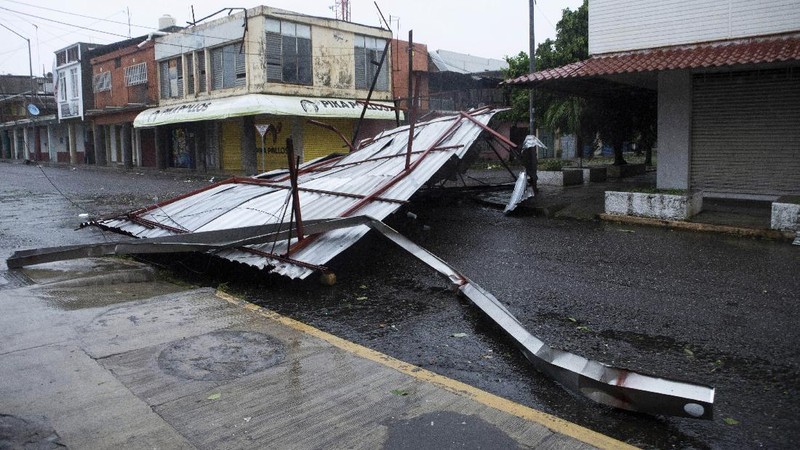 A car is stuck in a flooded street due to Hurricane Rick in Lazaro Cardenas, Mexico, Monday, Oct. 25, 2021. Hurricane Rick roared ashore along Mexico's southern Pacific coast early Monday with winds and heavy rain amid warnings of potential flash floods in the coastal mountains. (AP Photo/Armando Solis)