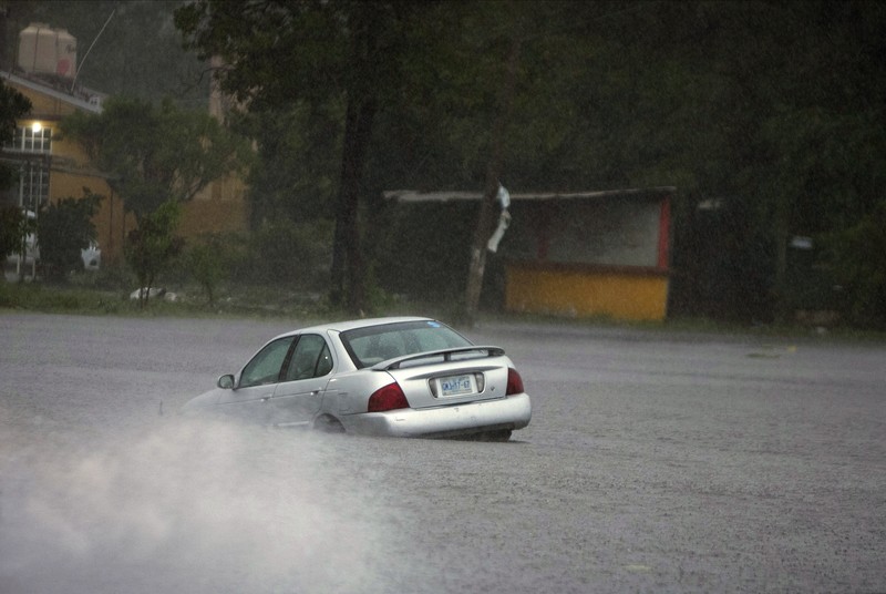 Mexico Tropical Weather A car is stuck in a flooded street due to Hurricane Rick in Lazaro Cardenas, Mexico, Monday, Oct. 25, 2021. Hurricane Rick roared ashore along Mexico's southern Pacific coast early Monday with winds and heavy rain amid warnings of potential flash floods in the coastal mountains. (AP Photo/Armando Solis)