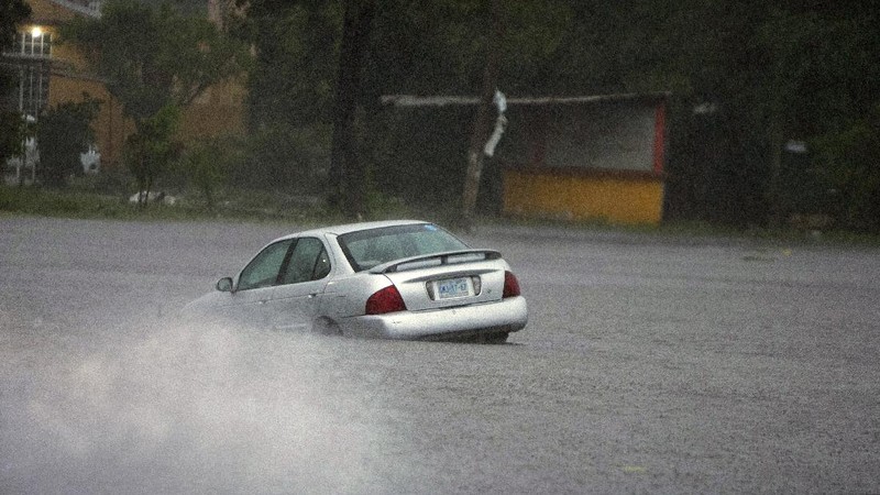 A car is stuck in a flooded street due to Hurricane Rick in Lazaro Cardenas, Mexico, Monday, Oct. 25, 2021. Hurricane Rick roared ashore along Mexico's southern Pacific coast early Monday with winds and heavy rain amid warnings of potential flash floods in the coastal mountains. (AP Photo/Armando Solis)