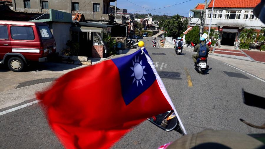 The flag of Taiwan flies on a scooter driving through a village on Kinmen, Taiwan, October 18, 2021. Sitting on the front line between Taiwan and China, Kinmen is the last place where the two engaged in major fighting, in 1958 at the height of the Cold War, and where memories of war are burned into minds decades later.  REUTERS/Ann Wang    SEARCH 