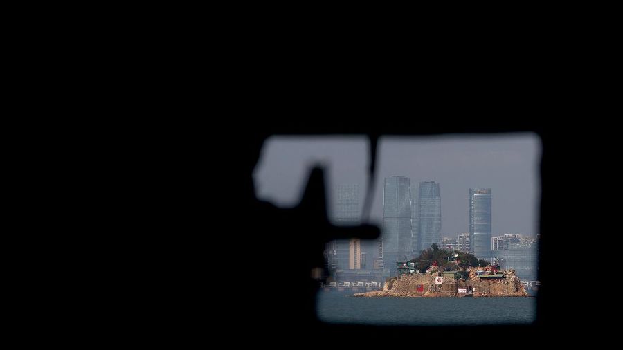 A mannequin of a soldier points a model gun from inside a bunker past Shihyu Islet, towards Xiamen, a coastal city in China, in Lieyu Township, Kinmen, Taiwan, October 19, 2021. Sitting on the front line between Taiwan and China, Kinmen is the last place where the two engaged in major fighting, in 1958 at the height of the Cold War, and where memories of war are burned into minds decades later.  REUTERS/Ann Wang    SEARCH 