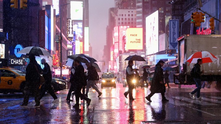 People hold umbrellas while crossing the street during a nor'easter in New York, U.S. October 26, 2021. REUTERS/Caitlin Ochs     TPX IMAGES OF THE DAY