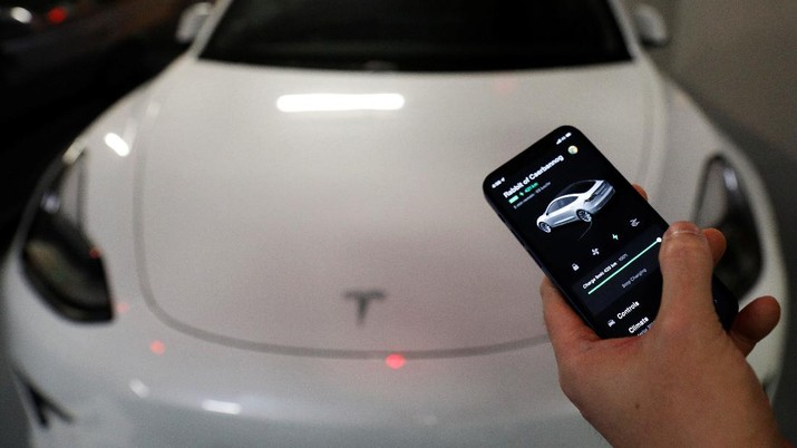 Tesla car owner Tim Shim, 42, shows on his mobile phone that his car is fully charged in Singapore October 25, 2021. REUTERS/Edgar Su