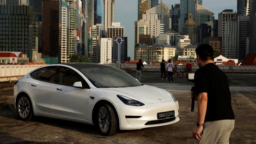 Tesla car owner Tim Shim, 42, films an “unboxing” video of his new Model 3 car in Singapore October 25, 2021. REUTERS/Edgar Su