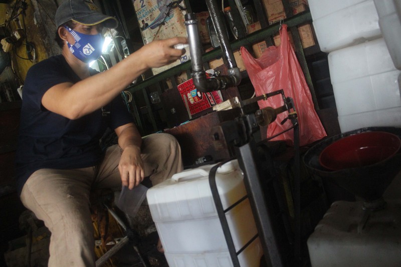 Pekerja memasukkan minyak goreng curah kedalam jiregen minyak di toko agen minyak goreng curah di kawasan Cipete, Jakarta, 29/10. Di tengah mahalnya harga minyak goreng (migor) karena kenaikan minyak sawit mentah (Crude Palm Oil/CPO) hingga 35 persen, membuat industri sawit nasional untung besar. Minyak goreng curah di Jakarta mengalami kenaikan. Untuk satu jeriken ukuran 17 kg dijual dengan harga Rp299.000. Mengutip dari Pusat Informasi Harga Pangan Strategis (PIHPS) Nasional, Senin (25/10/2021), jenis minyak goreng yang mengalami lonjakan adalah minyak goreng kemasan bermerek 1, minyak goreng kemasan bermerek 2, serta minyak goreng curah. Di pasar tradisional kenaikan berkisar Rp 2 ribu sampai Rp 4 ribu per liternya. Harga minyak goreng naik serempak, baik curah maupun kemasan bermerek.  (CNBC Indonesia/ Muhammad Sabki)