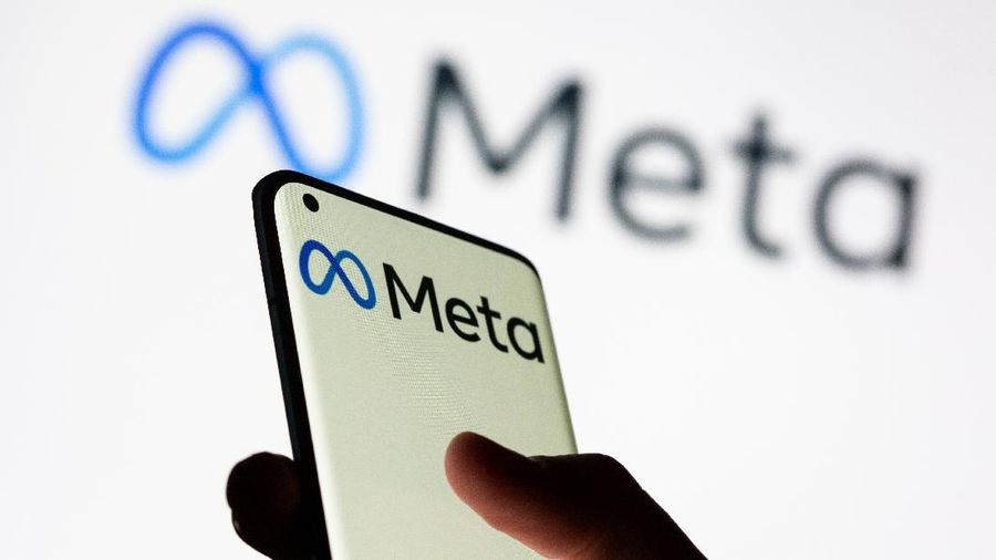 Woman holds smartphone with Meta logo in front of a displayed Facebook's new rebrand logo Meta in this illustration picture taken October 28, 2021. REUTERS/Dado Ruvic/Illustration