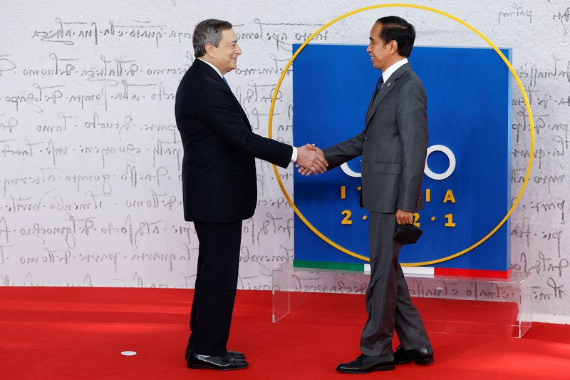 Italian Prime Minister Mario Draghi greets Indonesia's President Joko Widodo as he arrives for the G20 leaders summit in Rome, Italy October 30, 2021. REUTERS/Guglielmo Mangiapane