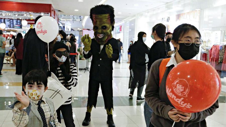 A participant wearing a costume walks on the bridge during a parade and costume competition ahead of Halloween at a shopping mall in Jakarta, Indonesia, October 30, 2021. REUTERS/Ajeng Dinar Ulfiana