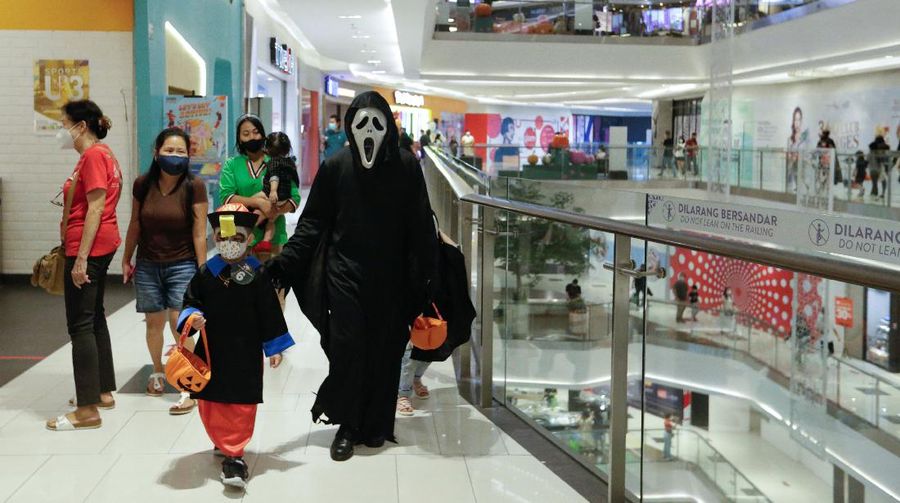 A participant wearing a costume walks on the bridge during a parade and costume competition ahead of Halloween at a shopping mall in Jakarta, Indonesia, October 30, 2021. REUTERS/Ajeng Dinar Ulfiana