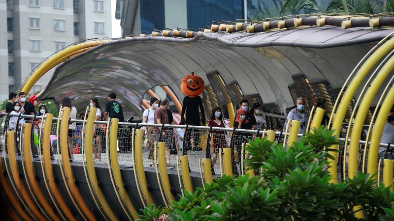 A participant wearing a costume walks on the bridge during a parade and costume competition ahead of Halloween at a shopping mall in Jakarta, Indonesia, October 30, 2021. REUTERS/Ajeng Dinar Ulfiana