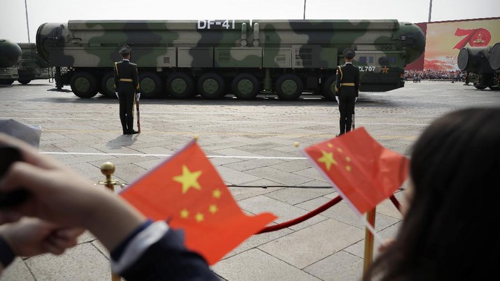 United States China Nuclear FILE - In this Oct. 1, 2019, file photo spectators wave Chinese flags as military vehicles carrying DF-41 ballistic missiles roll during a parade to commemorate the 70th anniversary of the founding of Communist China in Beijing. Trucks carrying weapons including a nuclear-armed missile designed to evade U.S. defenses rumbled through Beijing as the Communist Party celebrated its 70th anniversary in power. China appears to be moving faster toward a capability to launch its newer nuclear missiles from underground silos, possibly to improve its ability to respond promptly to a nuclear attack, according to an American expert who analyzed satellite images of recent construction at a missile training area. (AP Photo/Mark Schiefelbein, File)