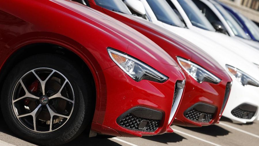 A long row of unsold 2020 Stelvio sports-utility vehicles sits at an Alfa Romeo dealership Sunday, July 19, 2020, in Highlands Ranch, Colo. (AP Photo/David Zalubowski)