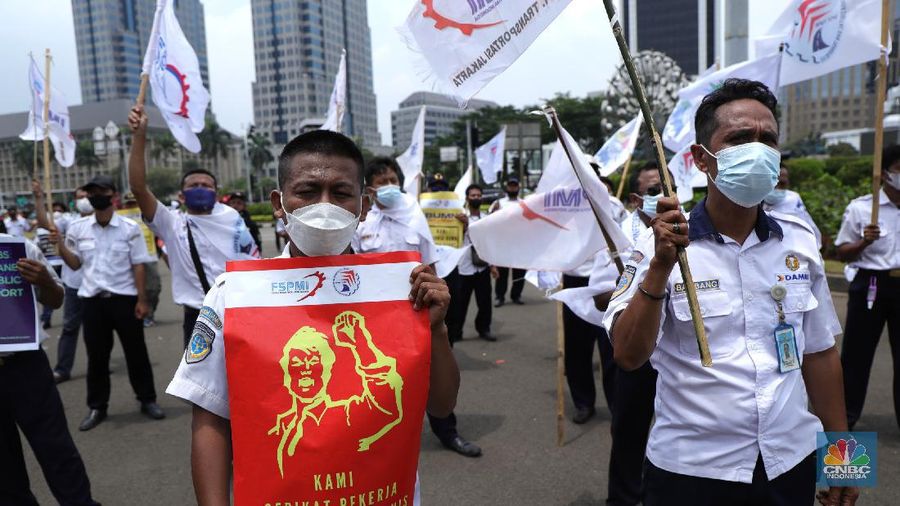 Puluhan massa pekerja dari Serikat Pekerja Dirgantara dan Transportasi (SPDT) Federasi Serikat Pekerja Metal Indonesia (FSPMI) menggelar aksi di Patung Kuda, Jakarta, Senin (1/11/2021). Aksi unjuk rasa digelar hari ini bertujuan sebagai upaya mereka mendesak kepada perum DAMRI agar membayar upah para karyawan yang sudah menunggak. Termasuk hal-hal lain yang belum dipenuhi oleh jasa transportasi. Pantauan dilokasi petugas kepolisian berjaga menggunakan pakaian Hazmat.  (CNBC Indonesia/ Tri Susilo)