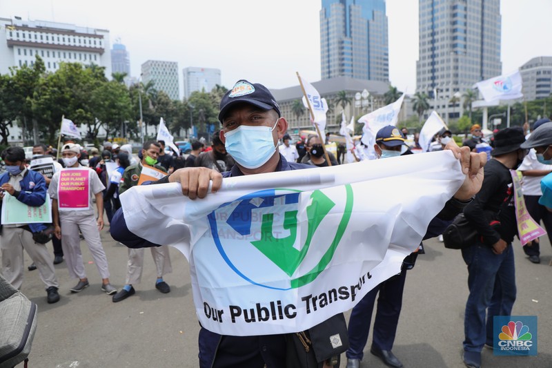 Puluhan massa pekerja dari Serikat Pekerja Dirgantara dan Transportasi (SPDT) Federasi Serikat Pekerja Metal Indonesia (FSPMI) menggelar aksi di Patung Kuda, Jakarta, Senin (1/11/2021). Aksi unjuk rasa digelar hari ini bertujuan sebagai upaya mereka mendesak kepada perum DAMRI agar membayar upah para karyawan yang sudah menunggak. Termasuk hal-hal lain yang belum dipenuhi oleh jasa transportasi. Pantauan dilokasi petugas kepolisian berjaga menggunakan pakaian Hazmat.  (CNBC Indonesia/ Tri Susilo)