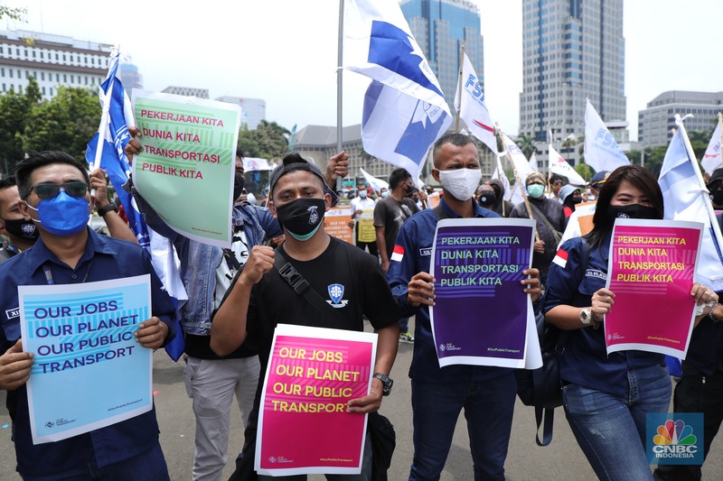 Puluhan massa pekerja dari Serikat Pekerja Dirgantara dan Transportasi (SPDT) Federasi Serikat Pekerja Metal Indonesia (FSPMI) menggelar aksi di Patung Kuda, Jakarta, Senin (1/11/2021). Aksi unjuk rasa digelar hari ini bertujuan sebagai upaya mereka mendesak kepada perum DAMRI agar membayar upah para karyawan yang sudah menunggak. Termasuk hal-hal lain yang belum dipenuhi oleh jasa transportasi. Pantauan dilokasi petugas kepolisian berjaga menggunakan pakaian Hazmat.  (CNBC Indonesia/ Tri Susilo)