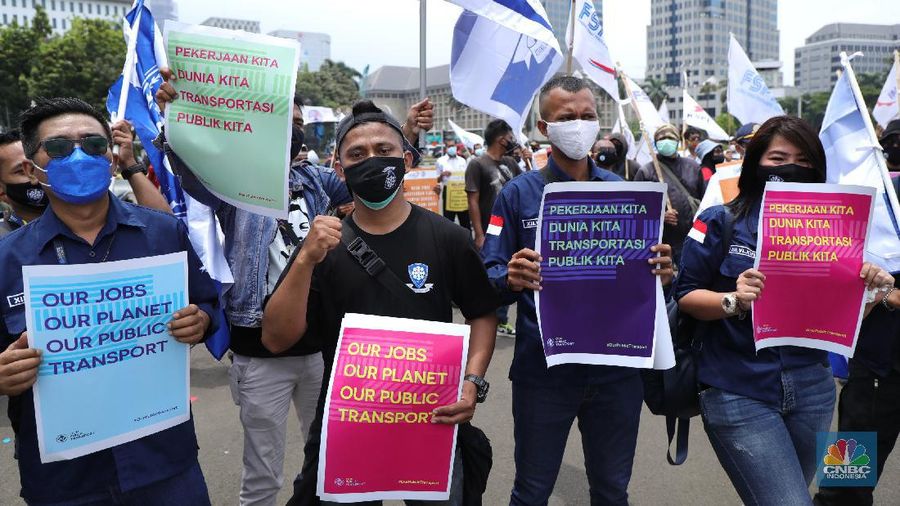 Puluhan massa pekerja dari Serikat Pekerja Dirgantara dan Transportasi (SPDT) Federasi Serikat Pekerja Metal Indonesia (FSPMI) menggelar aksi di Patung Kuda, Jakarta, Senin (1/11/2021). Aksi unjuk rasa digelar hari ini bertujuan sebagai upaya mereka mendesak kepada perum DAMRI agar membayar upah para karyawan yang sudah menunggak. Termasuk hal-hal lain yang belum dipenuhi oleh jasa transportasi. Pantauan dilokasi petugas kepolisian berjaga menggunakan pakaian Hazmat.  (CNBC Indonesia/ Tri Susilo)