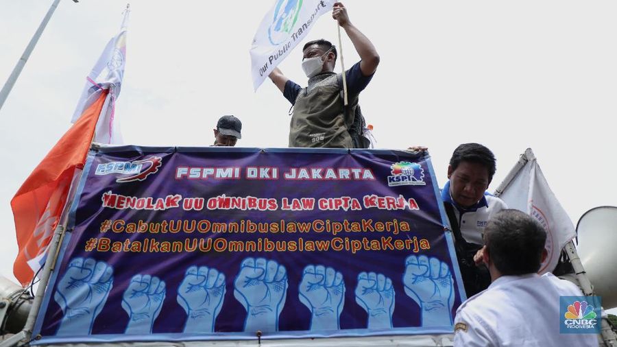 Puluhan massa pekerja dari Serikat Pekerja Dirgantara dan Transportasi (SPDT) Federasi Serikat Pekerja Metal Indonesia (FSPMI) menggelar aksi di Patung Kuda, Jakarta, Senin (1/11/2021). Aksi unjuk rasa digelar hari ini bertujuan sebagai upaya mereka mendesak kepada perum DAMRI agar membayar upah para karyawan yang sudah menunggak. Termasuk hal-hal lain yang belum dipenuhi oleh jasa transportasi. Pantauan dilokasi petugas kepolisian berjaga menggunakan pakaian Hazmat.  (CNBC Indonesia/ Tri Susilo)