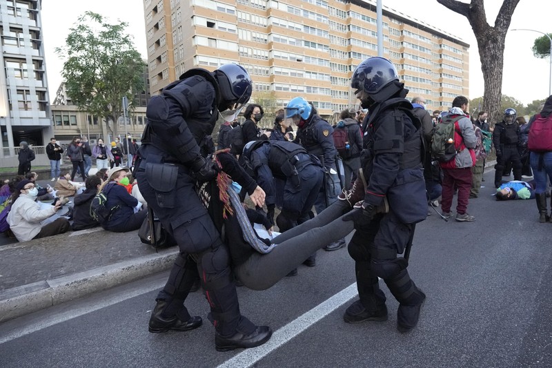 Italian Police remove climate activists trying to block traffic in front of the Italian Ministry of the Ecological Transition in Rome's via Cristoforo Colombo, one of the main road leading to La Nuvola (the cloud) convention center where the G20 summit is taking place, Saturday, Oct. 30, 2021. (AP Photo/Luca Bruno)