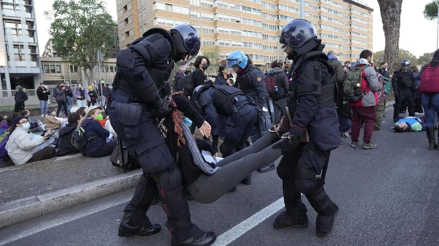 Italian Police remove climate activists trying to block traffic in front of the Italian Ministry of the Ecological Transition in Rome's via Cristoforo Colombo, one of the main road leading to La Nuvola (the cloud) convention center where the G20 summit is taking place, Saturday, Oct. 30, 2021. (AP Photo/Luca Bruno)