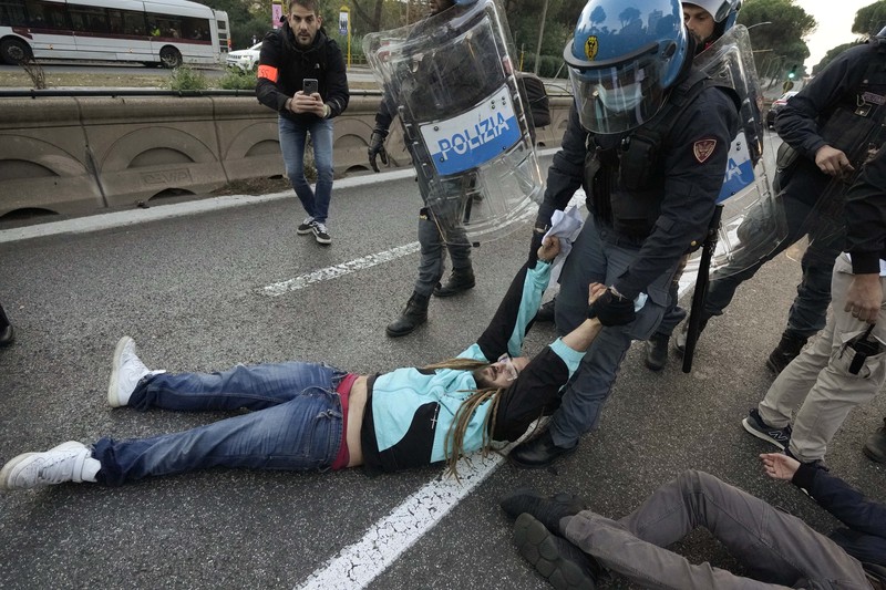 Italian Police remove climate activists trying to block traffic in front of the Italian Ministry of the Ecological Transition in Rome's via Cristoforo Colombo, one of the main road leading to La Nuvola (the cloud) convention center where the G20 summit is taking place, Saturday, Oct. 30, 2021. (AP Photo/Luca Bruno)