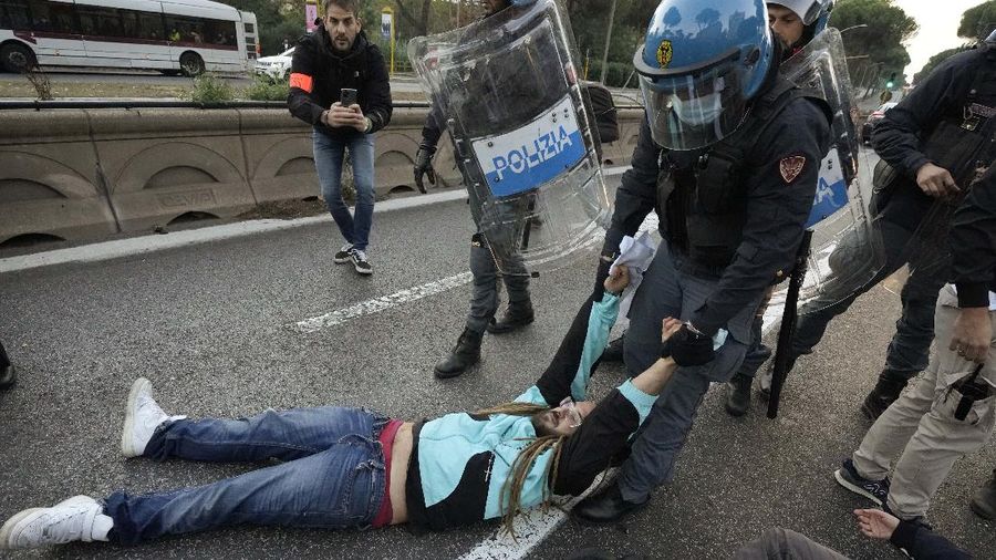 Italian Police remove climate activists trying to block traffic in front of the Italian Ministry of the Ecological Transition in Rome's via Cristoforo Colombo, one of the main road leading to La Nuvola (the cloud) convention center where the G20 summit is taking place, Saturday, Oct. 30, 2021. (AP Photo/Luca Bruno)