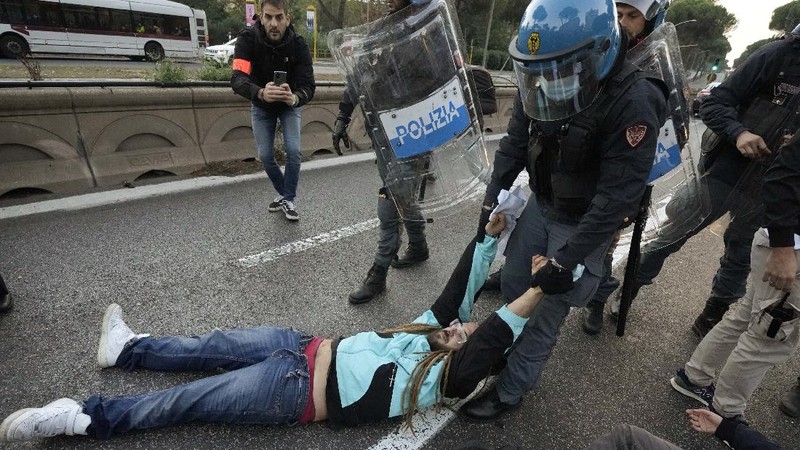 Italian Police remove climate activists trying to block traffic in front of the Italian Ministry of the Ecological Transition in Rome's via Cristoforo Colombo, one of the main road leading to La Nuvola (the cloud) convention center where the G20 summit is taking place, Saturday, Oct. 30, 2021. (AP Photo/Luca Bruno)