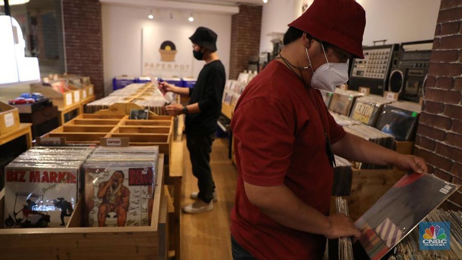 Pengunjung memilih piringan hitam di sebuah toko musik Paper Pot Record di kawasan Blok M, Jakarta, Senin (1/11/2021). Toko tersebut menjual koleksi piringan hitam yang diproduksi pada tahun 1950-an dengan harga Rp75 ribu hingga Rp200 ribu per keping, totalnya dengan koleksi sekitar 10.000 pirangan hitam. Toko piringan hitam di Jakarta yang masih tergolong baru ini terletak di dalam Blok M Plaza lantai 4, Bulungan, Jakarta Selatan. Menggunakan strategi cheapo box dimana puluhan rak berisi piringan hitam bekas dijual satuan hanya seharga 75rb, Paper Pot Records bisa menjadi pilihan kamu yang penasaran sama piringan hitam dan ingin membeli piringan hitam pertama untuk dikoleksi. Menurut pemilik, Ardi (31) selain ratusan piringan hitam murah, Paper Pot juga menjual beberapa piringan hitam yang tergolong langka dengan harga yang cukup miring untuk genre hip hop, rock, dan jazz