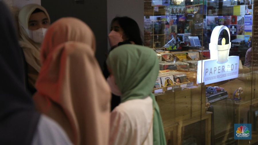 Pengunjung memilih piringan hitam di sebuah toko musik Paper Pot Record di kawasan Blok M, Jakarta, Senin (1/11/2021). Toko tersebut menjual koleksi piringan hitam yang diproduksi pada tahun 1950-an dengan harga Rp75 ribu hingga Rp200 ribu per keping, totalnya dengan koleksi sekitar 10.000 pirangan hitam. Toko piringan hitam di Jakarta yang masih tergolong baru ini terletak di dalam Blok M Plaza lantai 4, Bulungan, Jakarta Selatan. Menggunakan strategi cheapo box dimana puluhan rak berisi piringan hitam bekas dijual satuan hanya seharga 75rb, Paper Pot Records bisa menjadi pilihan kamu yang penasaran sama piringan hitam dan ingin membeli piringan hitam pertama untuk dikoleksi. Menurut pemilik, Ardi (31) selain ratusan piringan hitam murah, Paper Pot juga menjual beberapa piringan hitam yang tergolong langka dengan harga yang cukup miring untuk genre hip hop, rock, dan jazz