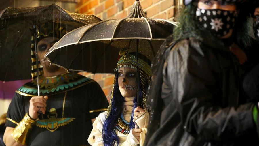 People wearing costumes wait in the rain to enter the Official Salem Witches' Halloween Ball in Salem, Massachusetts, U.S., October 30, 2021.   REUTERS/Reba Saldanha     TPX IMAGES OF THE DAY