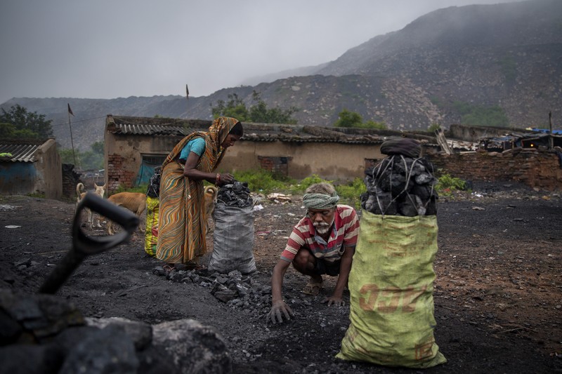 Buruh Angkut Batu Bara di India A man climbs a steep ridge with a basket of coal scavenged from a mine near Dhanbad, an eastern Indian city in Jharkhand state, Friday, Sept. 24, 2021. A 2021 Indian government study found that Jharkhand state -- among the poorest in India and the state with the nation’s largest coal reserves -- is also the most vulnerable Indian state to climate change. Efforts to fight climate change are being held back in part because coal, the biggest single source of climate-changing gases, provides cheap electricity and supports millions of jobs. It's one of the dilemmas facing world leaders gathered in Glasgow, Scotland this week in an attempt to stave off the worst effects of climate change. (AP Photo/Altaf Qadri)