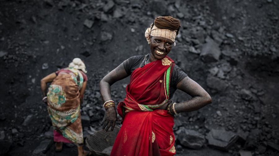 An Indian laborer smiles as she takes a break from loading coal into a truck in Dhanbad, an eastern Indian city in Jharkhand state, Friday, Sept. 24, 2021. A 2021 Indian government study found that Jharkhand state -- among the poorest in India and the state with the nation’s largest coal reserves -- is also the most vulnerable Indian state to climate change. Efforts to fight climate change are being held back in part because coal, the biggest single source of climate-changing gases, provides cheap electricity and supports millions of jobs. It's one of the dilemmas facing world leaders gathered in Glasgow, Scotland this week in an attempt to stave off the worst effects of climate change. (AP Photo/Altaf Qadri)