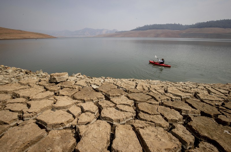 memancing di Danau Oroville saat permukaan air rendah karena kondisi kekeringan yang berkelanjutan di Oroville, California A kayaker fishes in Lake Oroville as water levels remain low due to continuing drought conditions in Oroville, Calif., Aug. 22, 2021. (AP Photo/Ethan Swope)