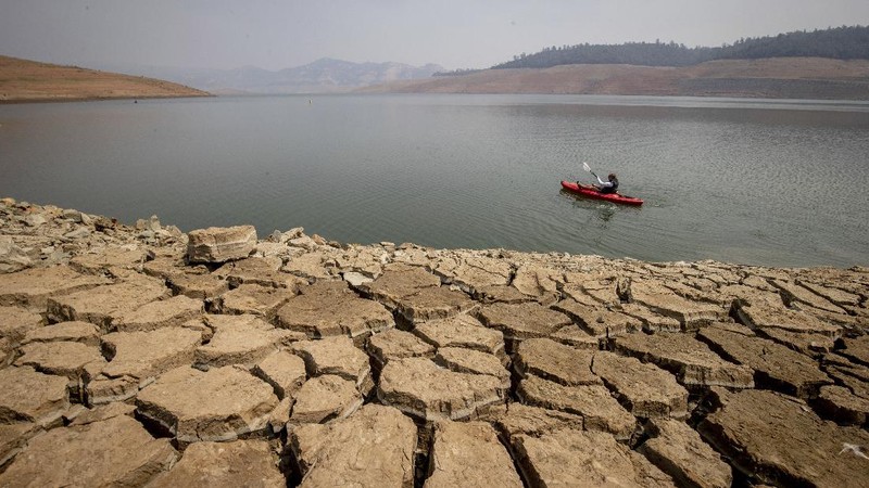 A kayaker fishes in Lake Oroville as water levels remain low due to continuing drought conditions in Oroville, Calif., Aug. 22, 2021. (AP Photo/Ethan Swope)