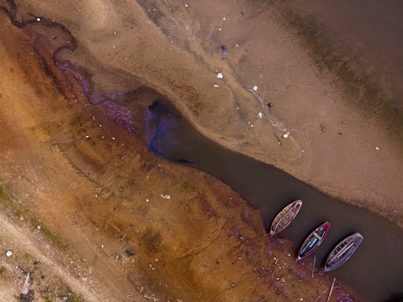 A kayaker fishes in Lake Oroville as water levels remain low due to continuing drought conditions in Oroville, Calif., Aug. 22, 2021. (AP Photo/Ethan Swope)