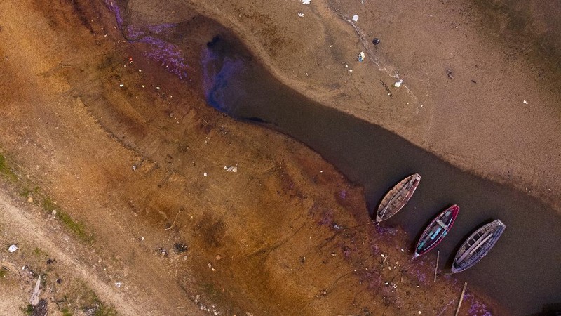 A kayaker fishes in Lake Oroville as water levels remain low due to continuing drought conditions in Oroville, Calif., Aug. 22, 2021. (AP Photo/Ethan Swope)