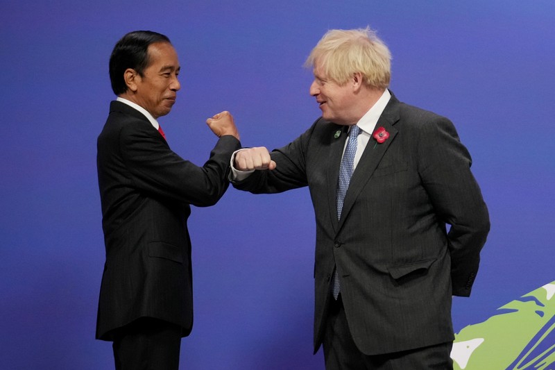 Britain's Prime Minister Boris Johnson (R) greets Indonesia's President Joko Widodo during arrivals at the UN Climate Change Conference (COP26) in Glasgow, Scotland, Britain November 1, 2021. Christopher Furlong/Pool via REUTERS
