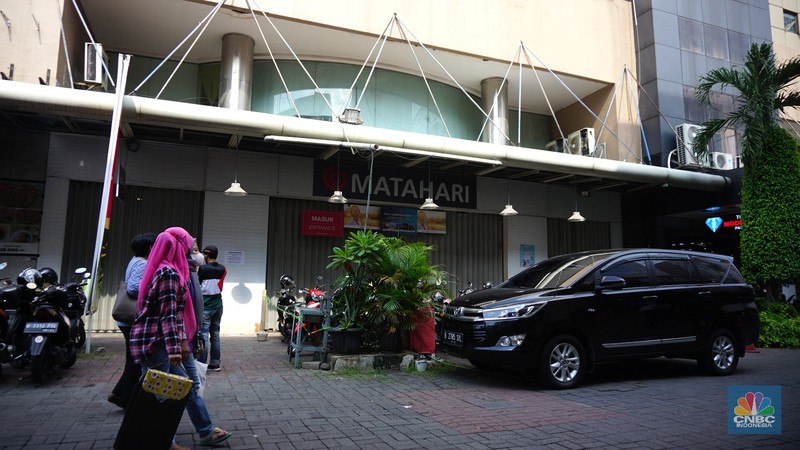Warga melihat selembaran kertas yang tertempel digerai Matahari Store, Pasar Baru, Jakarta, Selasa (2/11/2021). Matahari Departemen Store menutup gerainya yang ada di Pasar Baru, didrpan lokasi hanya terpakir kendaraan pengunjung gerai lain. Menurut petugas parkir 