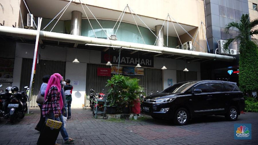 Warga melihat selembaran kertas yang tertempel digerai Matahari Store, Pasar Baru, Jakarta, Selasa (2/11/2021). Matahari Departemen Store menutup gerainya yang ada di Pasar Baru, didrpan lokasi hanya terpakir kendaraan pengunjung gerai lain. Menurut petugas parkir 
