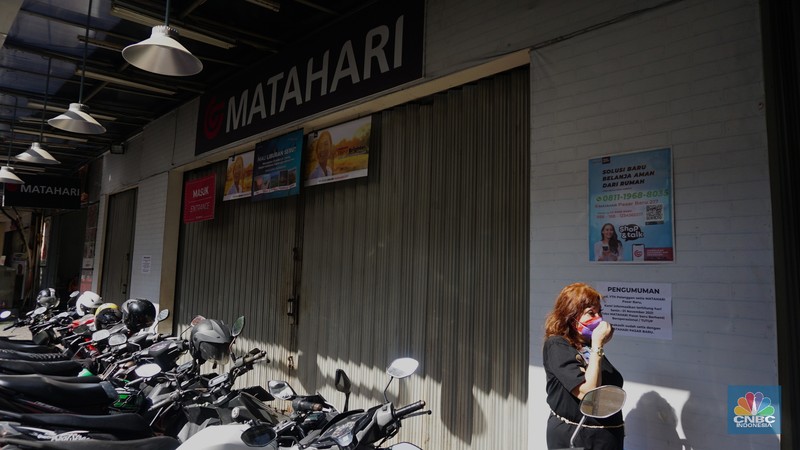 Suasana Matahari Pasar Baru yang Tutup Warga melihat selembaran kertas yang tertempel digerai Matahari Store, Pasar Baru, Jakarta, Selasa (2/11/2021). Matahari Departemen Store menutup gerainya yang ada di Pasar Baru, didrpan lokasi hanya terpakir kendaraan pengunjung gerai lain. Menurut petugas parkir
