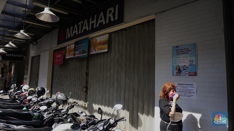 Warga melihat selembaran kertas yang tertempel digerai Matahari Store, Pasar Baru, Jakarta, Selasa (2/11/2021). Matahari Departemen Store menutup gerainya yang ada di Pasar Baru, didrpan lokasi hanya terpakir kendaraan pengunjung gerai lain. Menurut petugas parkir 
