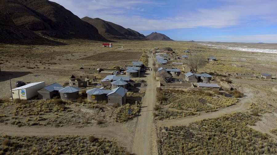 Residents walk along a dirt road in the Urus del Lago Poopo indigenous community, which sits along the salt-crusted former shoreline of Lake Poopo, in Punaca, Bolivia, Monday, May 24, 2021. Bolivia's second-largest lake dried up about five years ago, victim of shrinking glaciers, water diversions for farming and contamination. (AP Photo/Juan Karita)