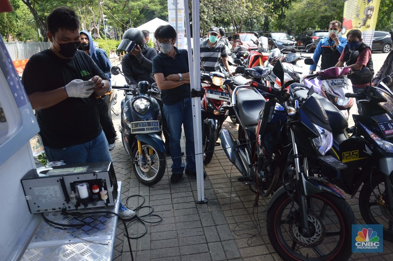 Uji Emisi Motor Petugas melakukan uji emisi gas buang kendaraan di Lapangan Parkir IRTI Monas, Jakarta, Selasa (2/11/2021). Pemerintah Provinsi DKI Jakarta akan memberlakukan sanksi tilang pada sepeda motor dan mobil yang kadar emisi gas buangnya melebihi batas yang telah ditentukan mulai 13 November 2021. Masyarakat pun diharapkan segera melakukan uji emisi pada kendaraannya. Terdapat 15 lokasi bengkel dan kios pelaksana uji emisi di Jakarta untuk warga yang ingin melakukan uji emisi kendaraan sebelum diterapkannya sanksi tilang berupa denda sebesar Rp 500.000 untuk mobil dan motor Rp 250.000. Sanksi tilang ini berlaku mulai 13 November 2021 berdasarkan Undang-Undang Lalu Lintas dan Angkutan Jalan pada Pasal 285 dan Pasal 286 dan Peraturan Gubernur DKI Jakarta No. 66 Tahun 2020 tentang Uji Emisi Gas Buang Kendaraan Bermotor. (CNBC Indonesia/ Muhammad Sabki)
