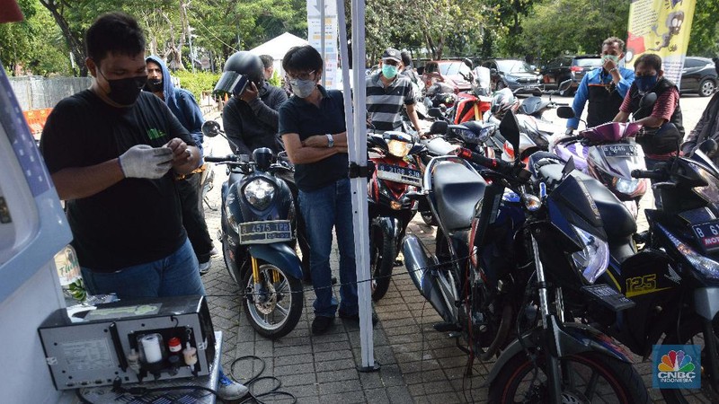 Petugas melakukan uji emisi gas buang kendaraan di Lapangan Parkir IRTI Monas, Jakarta, Selasa (2/11/2021). Pemerintah Provinsi DKI Jakarta akan memberlakukan sanksi tilang pada sepeda motor dan mobil yang kadar emisi gas buangnya melebihi batas yang telah ditentukan mulai 13 November 2021. Masyarakat pun diharapkan segera melakukan uji emisi pada kendaraannya. Terdapat 15 lokasi bengkel dan kios pelaksana uji emisi di Jakarta untuk warga yang ingin melakukan uji emisi kendaraan sebelum diterapkannya sanksi tilang berupa denda sebesar Rp 500.000 untuk mobil dan motor Rp 250.000. Sanksi tilang ini berlaku mulai 13 November 2021 berdasarkan Undang-Undang Lalu Lintas dan Angkutan Jalan pada Pasal 285 dan Pasal 286 dan Peraturan Gubernur DKI Jakarta No. 66 Tahun 2020 tentang Uji Emisi Gas Buang Kendaraan Bermotor. (CNBC Indonesia/ Muhammad Sabki)