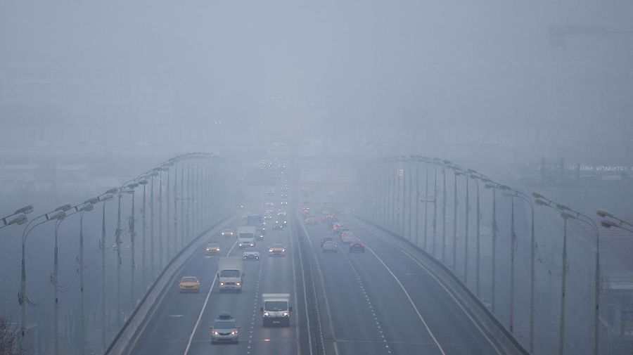 A pedestrian walk through morning fog along a pond in Ostankino in Moscow, Russia, Tuesday, Nov. 2, 2021. More than 30 flights were delayed or canceled at three airports in the capital due to fog. (AP Photo/Alexander Zemlianichenko)