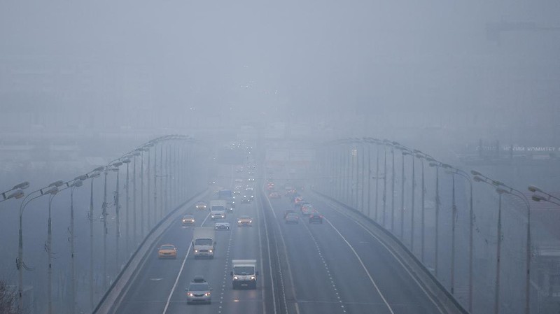 A pedestrian walk through morning fog along a pond in Ostankino in Moscow, Russia, Tuesday, Nov. 2, 2021. More than 30 flights were delayed or canceled at three airports in the capital due to fog. (AP Photo/Alexander Zemlianichenko)