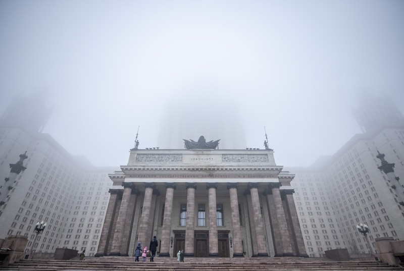 A pedestrian walk through morning fog along a pond in Ostankino in Moscow, Russia, Tuesday, Nov. 2, 2021. More than 30 flights were delayed or canceled at three airports in the capital due to fog. (AP Photo/Alexander Zemlianichenko)