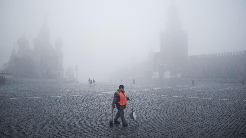 A pedestrian walk through morning fog along a pond in Ostankino in Moscow, Russia, Tuesday, Nov. 2, 2021. More than 30 flights were delayed or canceled at three airports in the capital due to fog. (AP Photo/Alexander Zemlianichenko)