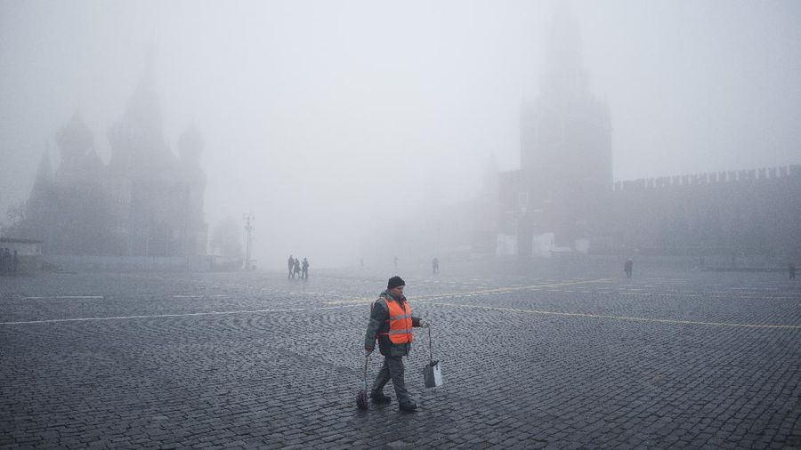 Kabut di Moskow Rusia A municipal worker walks in Red square past the Spasskaya Tower, right, and St. Basil's Cathedral visible through the fog in Moscow, Russia, Tuesday, Nov. 2, 2021. A dense fog engulfed the Russian capital on Tuesday, causing numerous flight delays at Moscow's airports. (AP Photo/Pavel Golovkin)