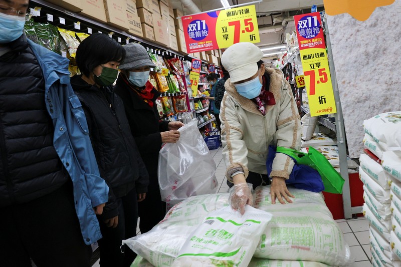 People look at products in the flour section of a supermarket following outbreak of the coronavirus disease (COVID-19) in Beijing, China, November 3, 2021. REUTERS/Thomas Peter